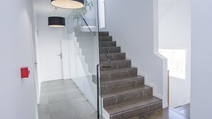 A modern staircase with glass railings and a black lamp. - Hostal La Isla (Carboneras)