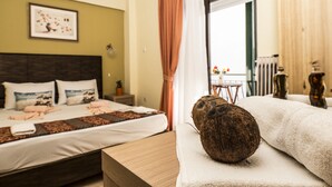 Habitación de hotel con cama, mesita de noche, ventana con cortinas y vistas al exterior.
