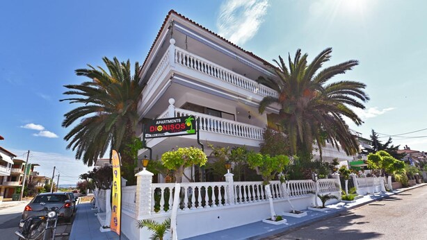 Un edificio de dos pisos con un cartel que dice 'Apartments Dionisos'.