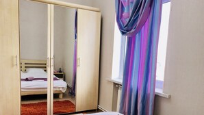 A bedroom with a bed, a wardrobe, a window with curtains, and a bathroom visible through the wardrobe doors. - Check-in apartment Metropark Mall (Baku)