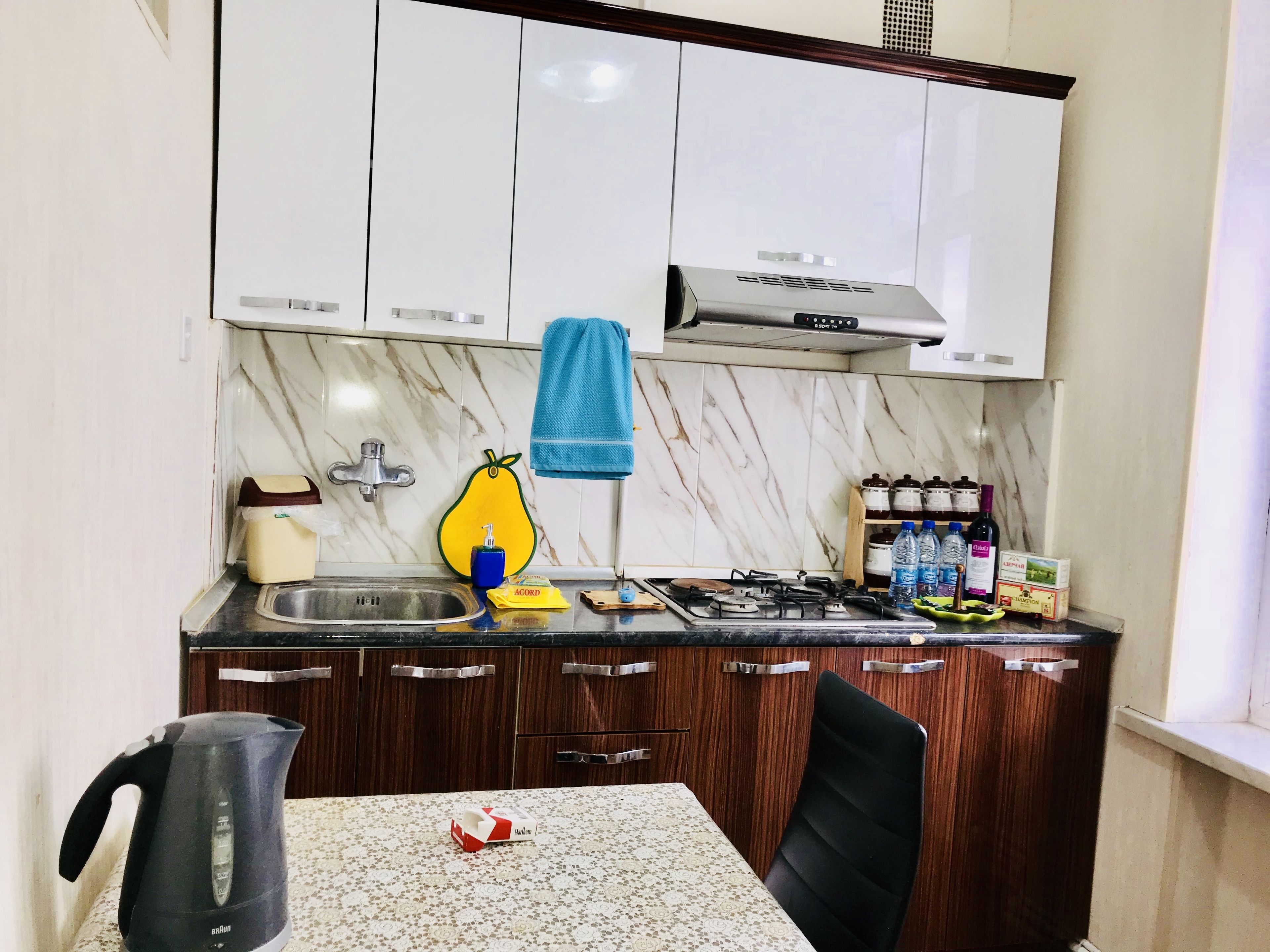 A compact kitchen with a gas stove, a sink, and wooden cabinets.