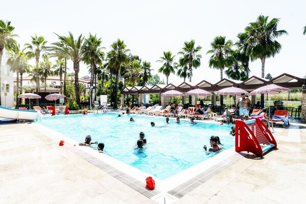 Una piscina al aire libre, sombrillas, tumbonas