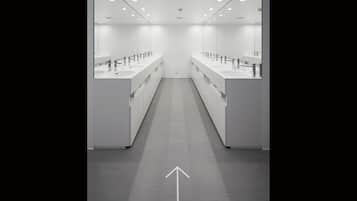 A modern, well-lit public restroom with multiple sinks and mirrors.