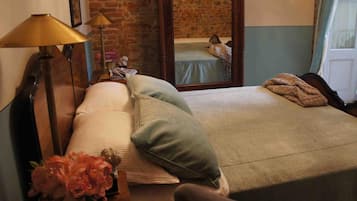Une chambre à coucher avec un lit, une chaise, une lampe et un miroir.