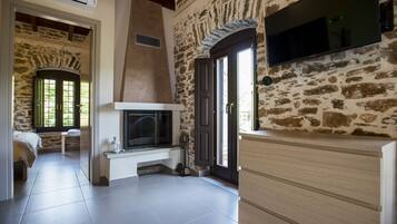 Suite junior, balcón | Sala de estar | Una televisión de pantalla plana, una chimenea