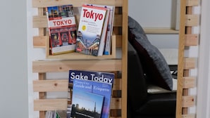 A wooden bookshelf with travel books and a mirror. - Rooms (Tokyo)