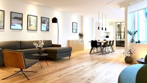 Una sala de estar moderna con un sofá, una mesa de centro y una zona de comedor con sillas y una mesa.