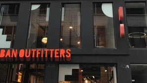 Un edificio con varias ventanas y un escaparate con la leyenda "BAN OUTFITTERS".