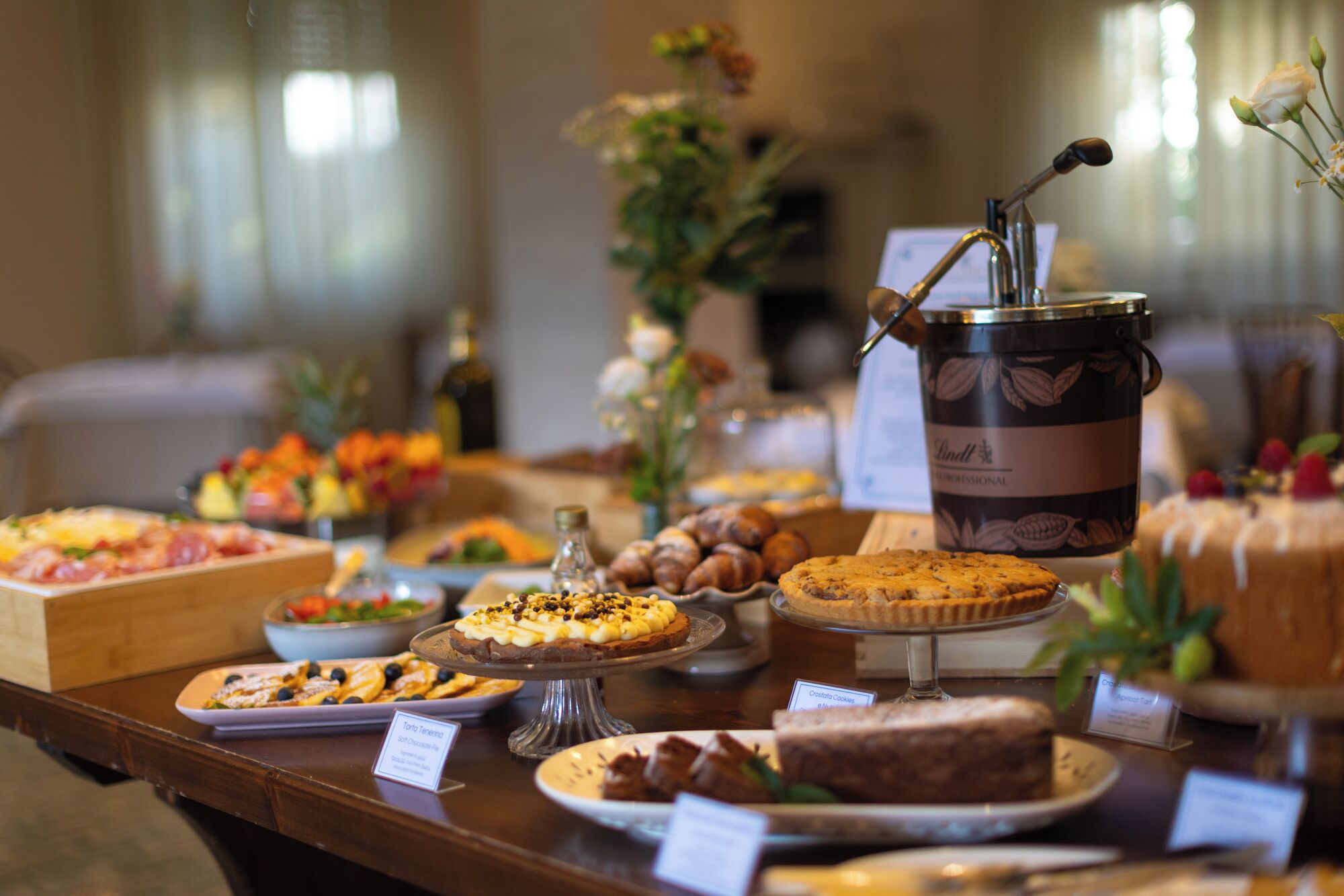 A buffet table with various desserts and a coffee urn.
