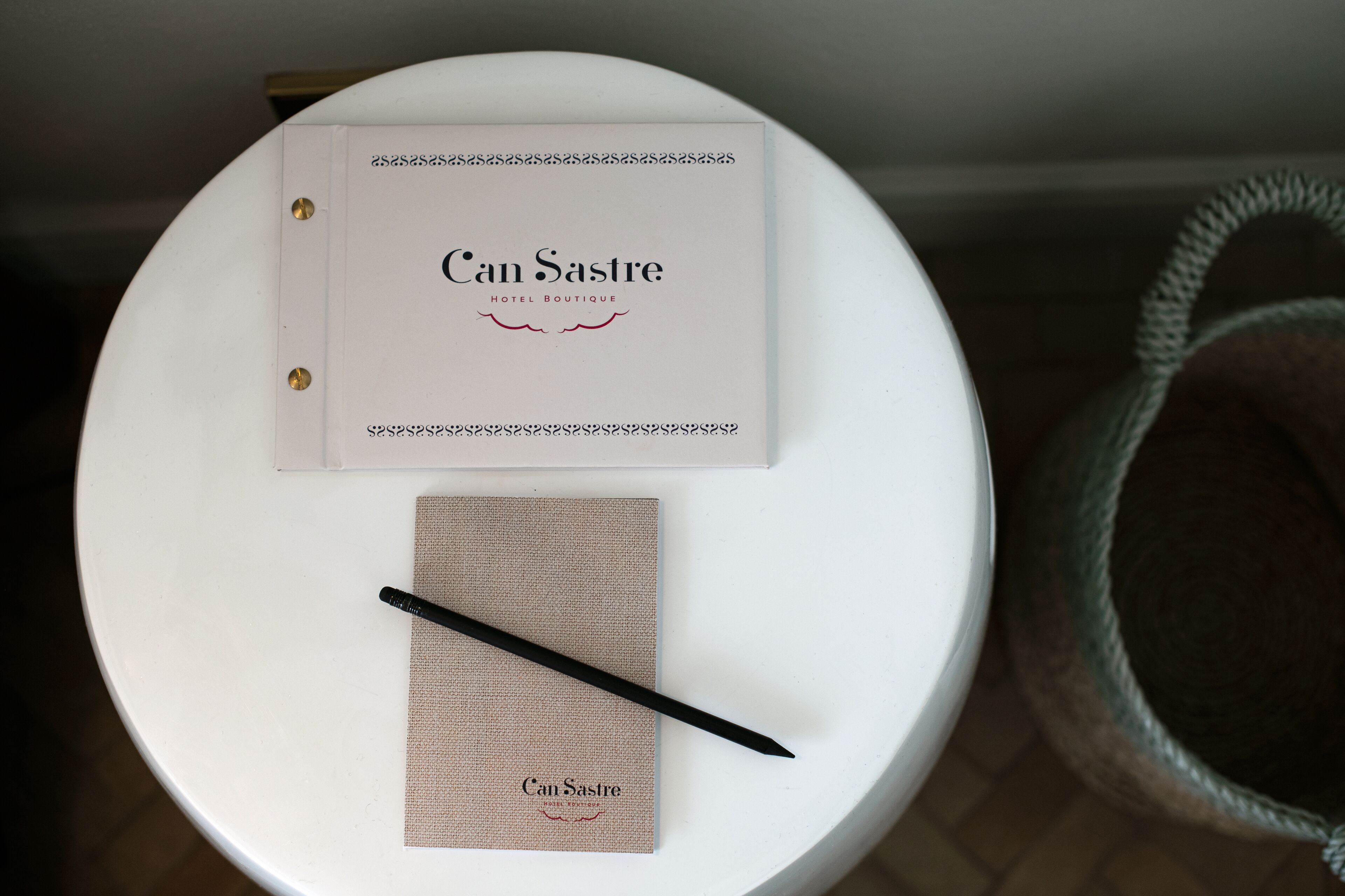 Une table ronde blanche, avec un classeur blanc et un stylo dessus.