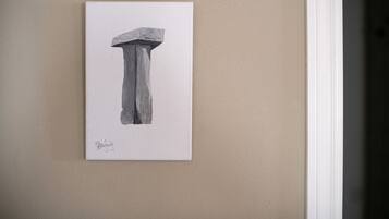 A framed artwork of a column on a beige wall.