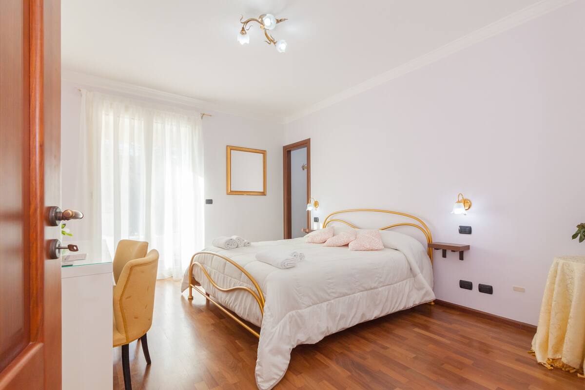 A bedroom with a bed, a desk, and a chair.