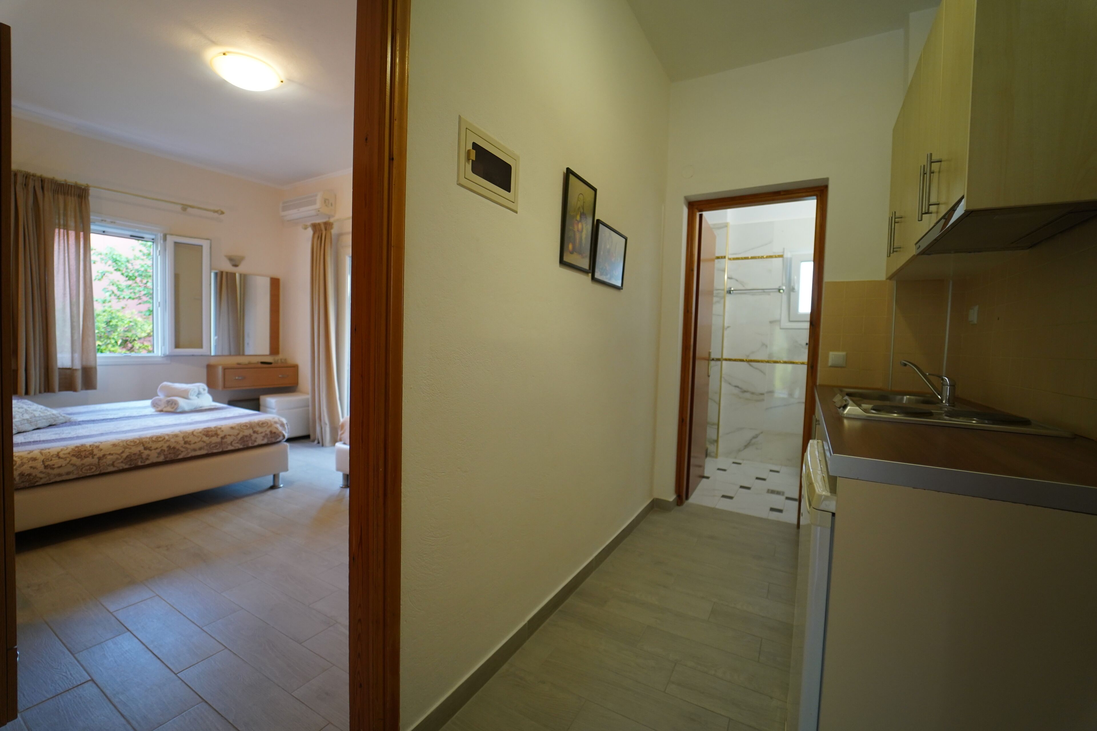 Habitación de hotel con cama, kitchenette pequeña y baño.