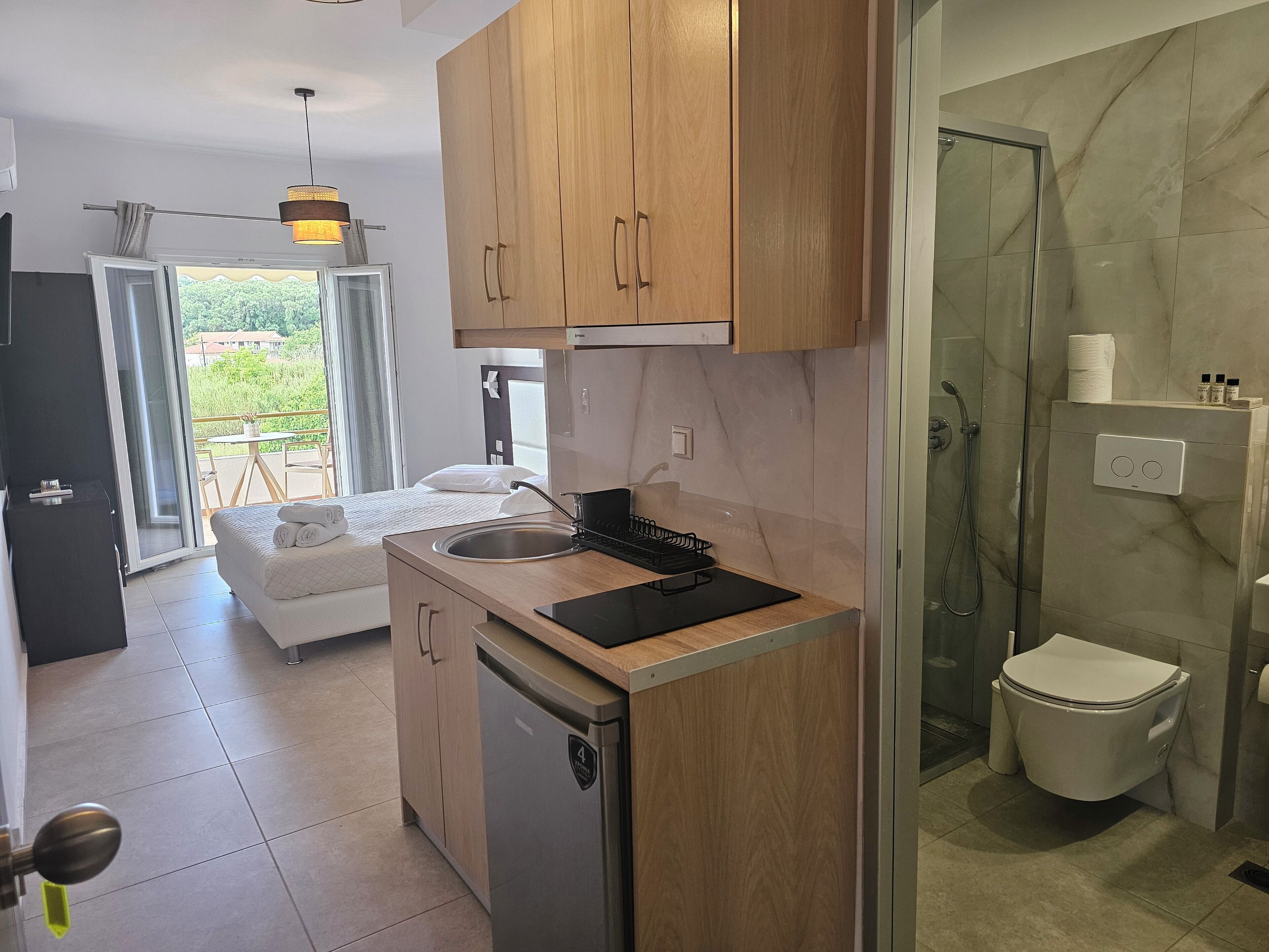 A modern kitchen with wooden cabinets, a sink, and a compact refrigerator.