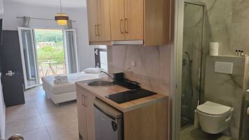 A modern kitchen with wooden cabinets, a sink, and a compact refrigerator.