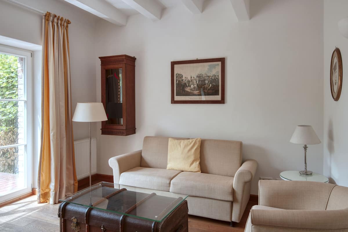 A living room with a sofa, a glass coffee table, a wooden cabinet, and a framed picture on the wall.