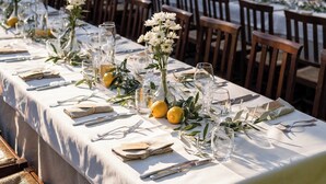 A long dining table set outdoors with white tablecloths, glassware, and floral centerpieces. - Casina Dei Preti (Conversano)