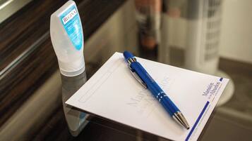 A hand sanitizer bottle and a blue pen on a white card with text.