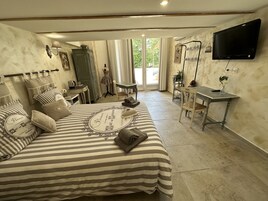 Une chambre à coucher avec un lit, un bureau, une chaise et un téléviseur.