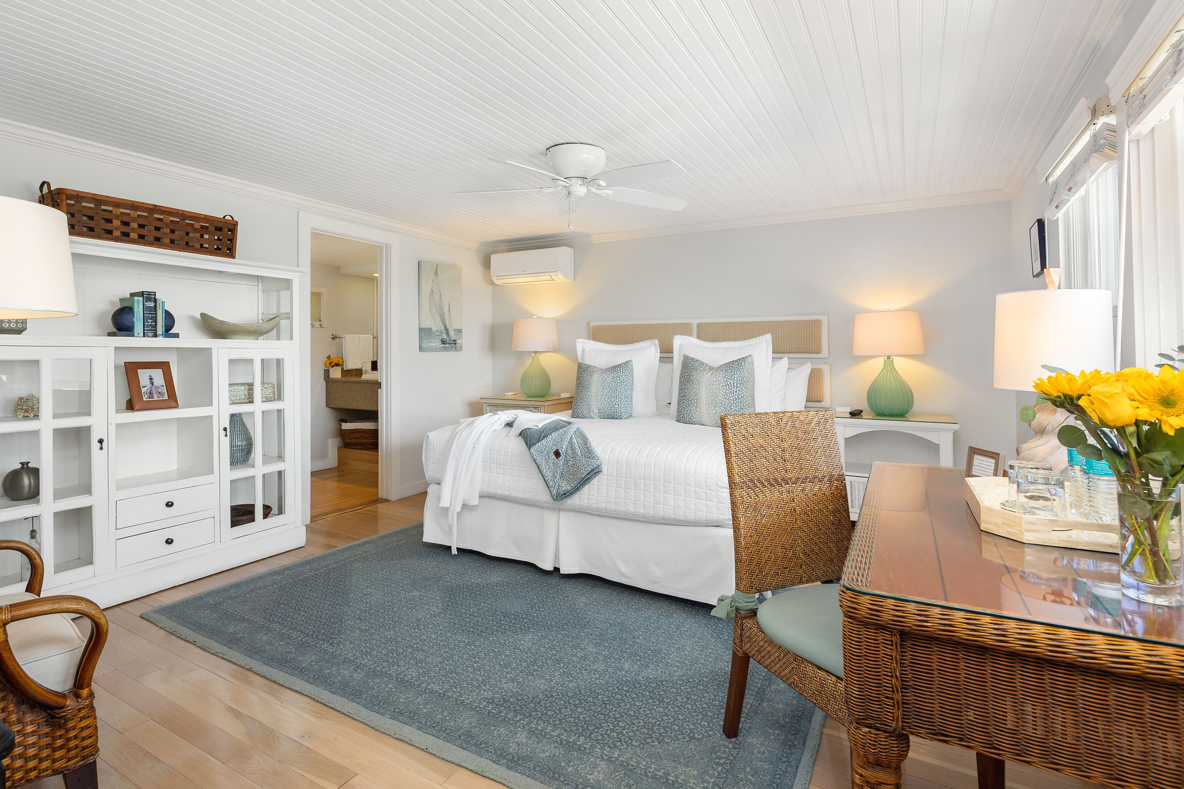 A bedroom with a bed, bedside tables, a chair, a desk, and a bookshelf.