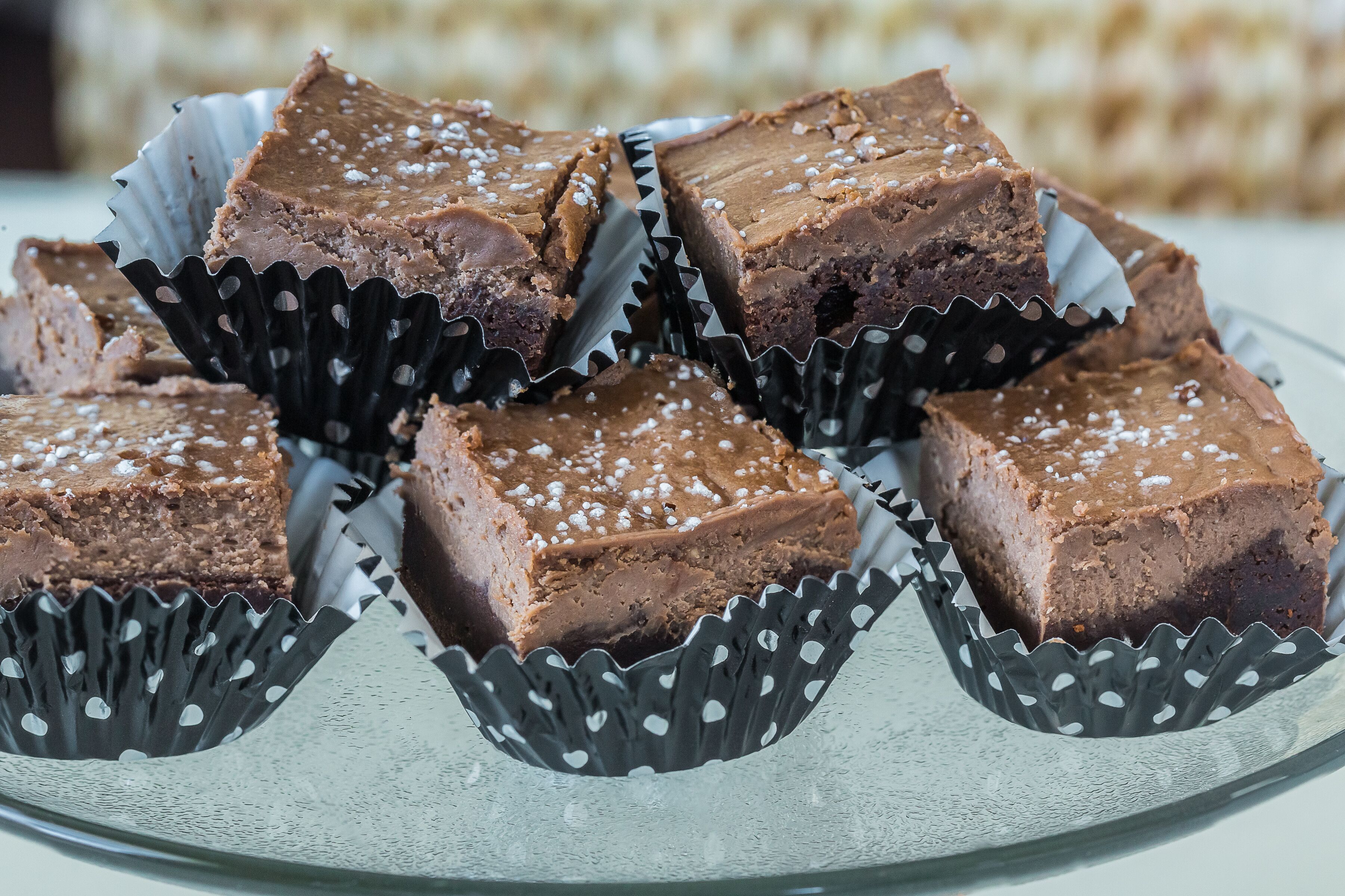 Un plato de brownies en vasos de papel con superficie texturizada.