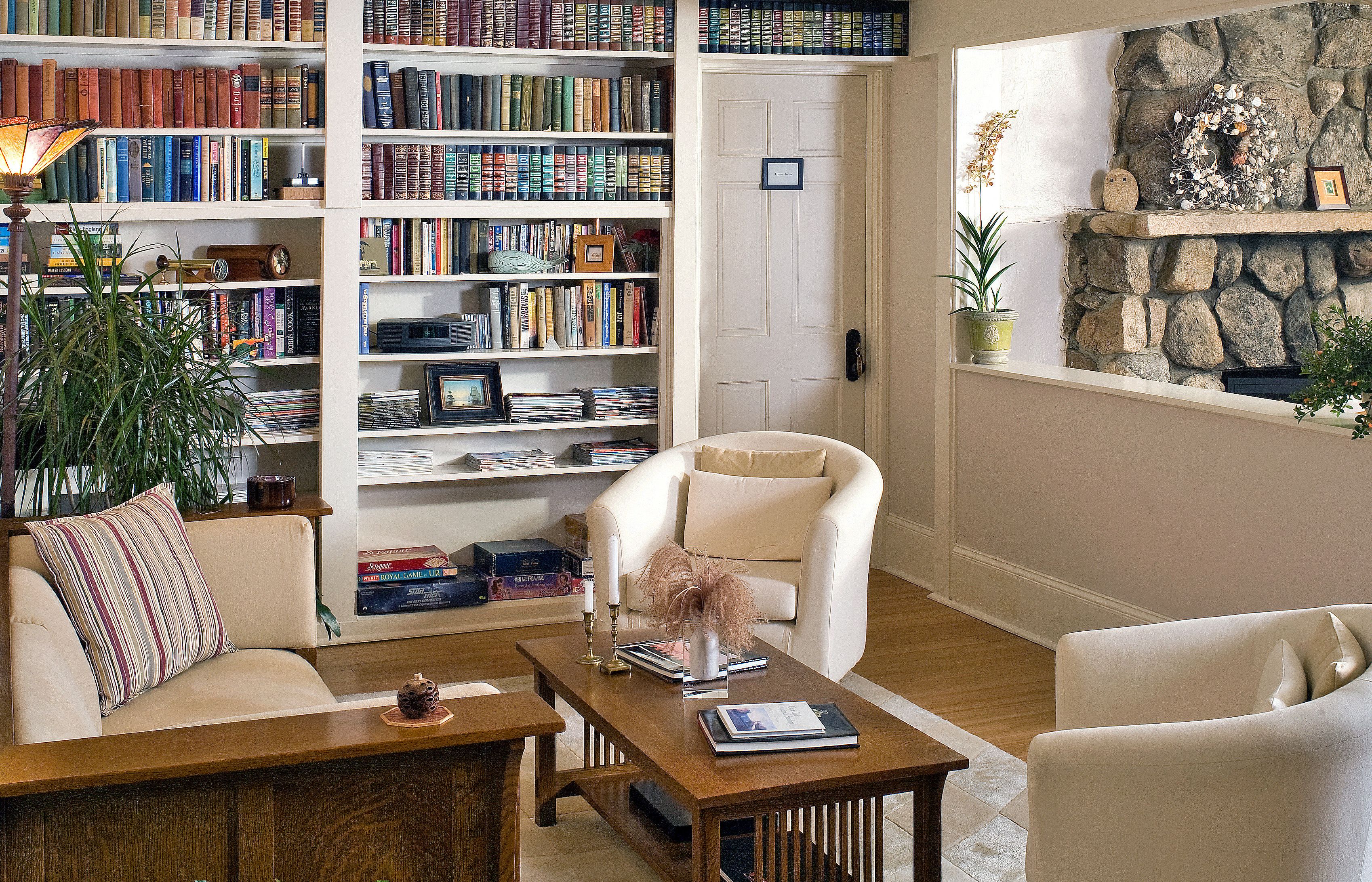 Un salon chaleureux avec une bibliothèque, une cheminée et un coin salon confortable.