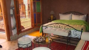 A bedroom with a bed, a small round table, and a chair. - Riad BenSaid (Marrakech)