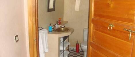 A bathroom with a sink, mirror, and toilet.