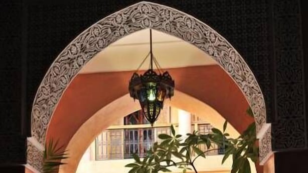 An indoor courtyard with a tiled floor, a central fountain, and a wooden door. - Riad BenSaid (Marrakech)