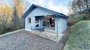 Une petite maison de plain-pied dotée d’un patio couvert.