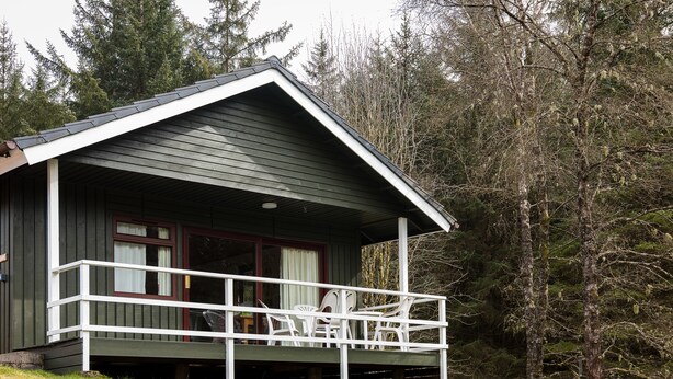 Une petite cabane dotée d’un balcon et d’une véranda couverte.