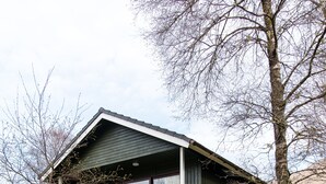 Un chalet rustique doté d’un porche et d’un espace salon extérieur.