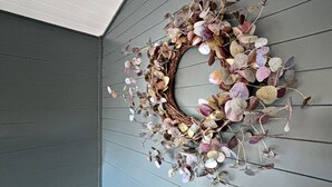 Ein Kranz aus getrockneten Blättern und Zweigen an einer Wand.