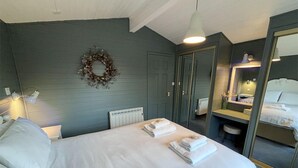 Ein Schlafzimmer mit einem Bett, einem Spiegel, einer Heizung und einer Wandleuchte.