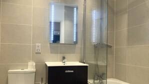 Une salle de bain avec des toilettes, un lavabo et une douche.