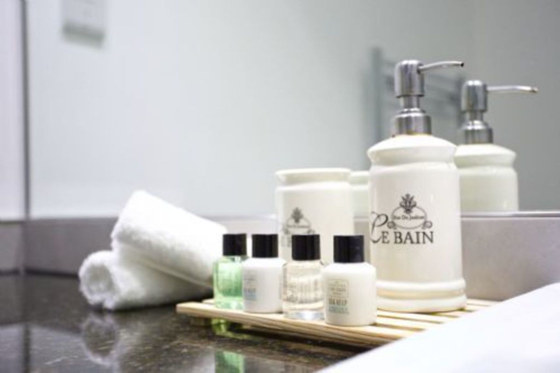 A bathroom counter with toiletries including a bottle labeled "Le Bain" and a towel.