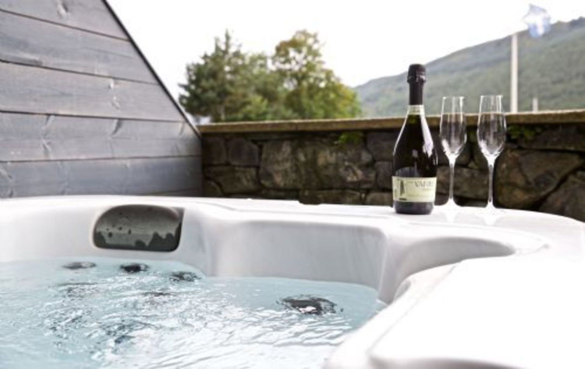 Ein Whirlpool mit einer Weinflasche und zwei Gläsern.