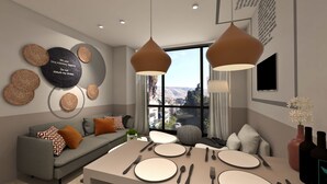 A modern dining area with a table set for four, a grey sofa with patterned cushions, and a city view through large windows. - Great Living Apartments (Athens)