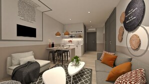 A modern living room with a sofa, coffee table, and a kitchen in the background. - Great Living Apartments (Athens)