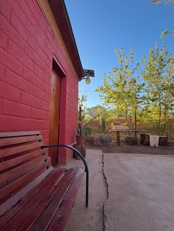 Un edificio de ladrillo rojo con un banco de madera en el exterior.