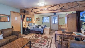 Ein gemütliches Zimmer mit einem Bett, einem Holztisch, einer Couch und einem Kamin.