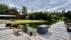 Eine Holzstele führt in einen stillen See, mit einer Bank und einer Aufbewahrungsbox darauf.