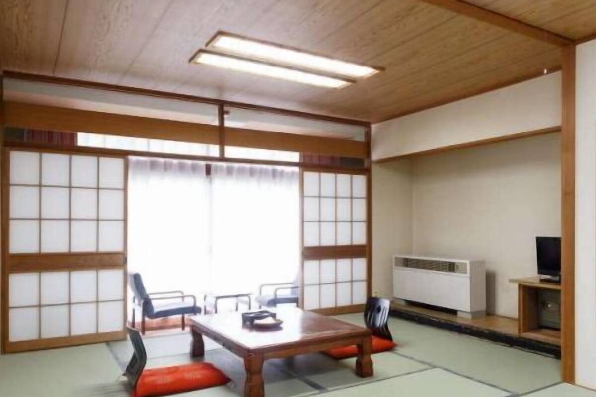 Een traditionele Japanse kamer met tatami vloerbedekking, een lage tafel en schuifdeuren.