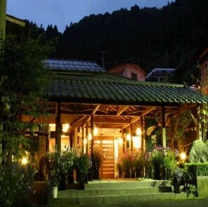A building with a green-tiled roof, wooden structure, and potted plants. - Tsutiu Onsen Yamaneya Ryokan (Fukushima)