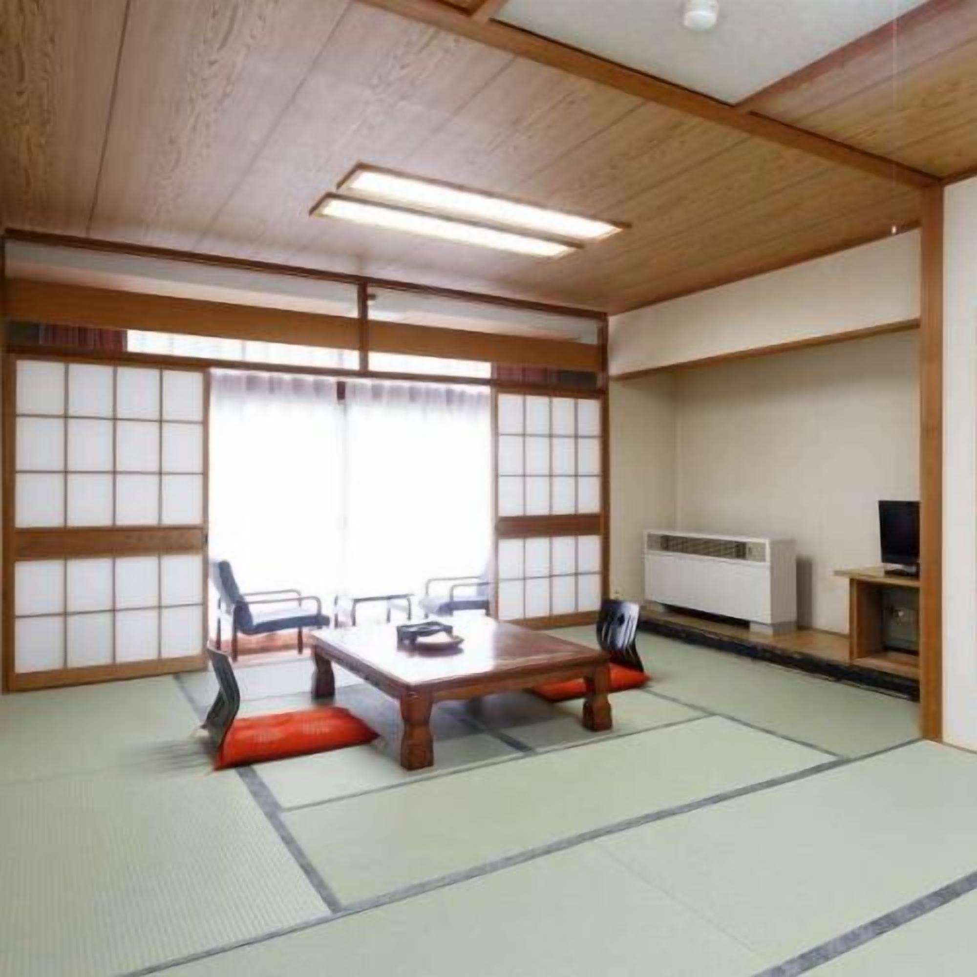 Ein traditioneller japanischer Raum mit Tatami-Bodenbelag, einem niedrigen Tisch und Shoji-Schiebetüren.