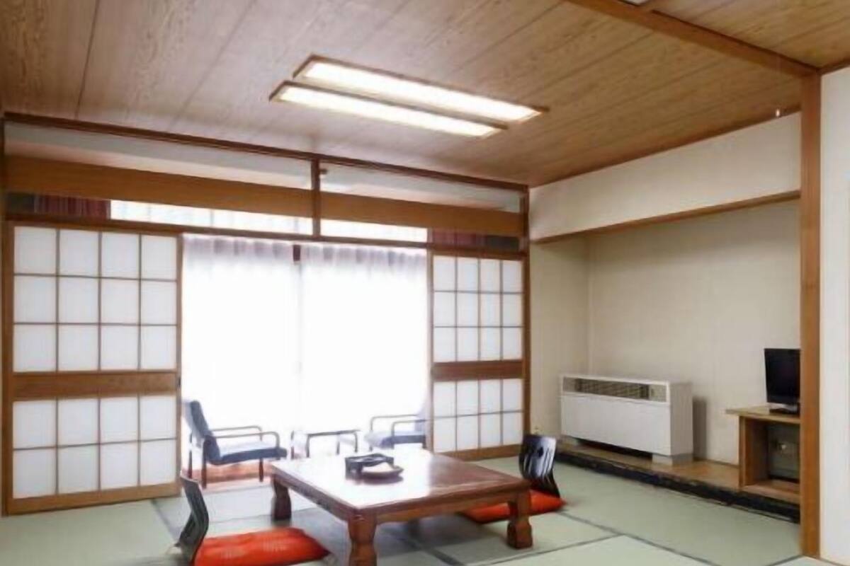 Een traditionele Japanse kamer met tatami vloeren, een lage tafel en shoji schermen.