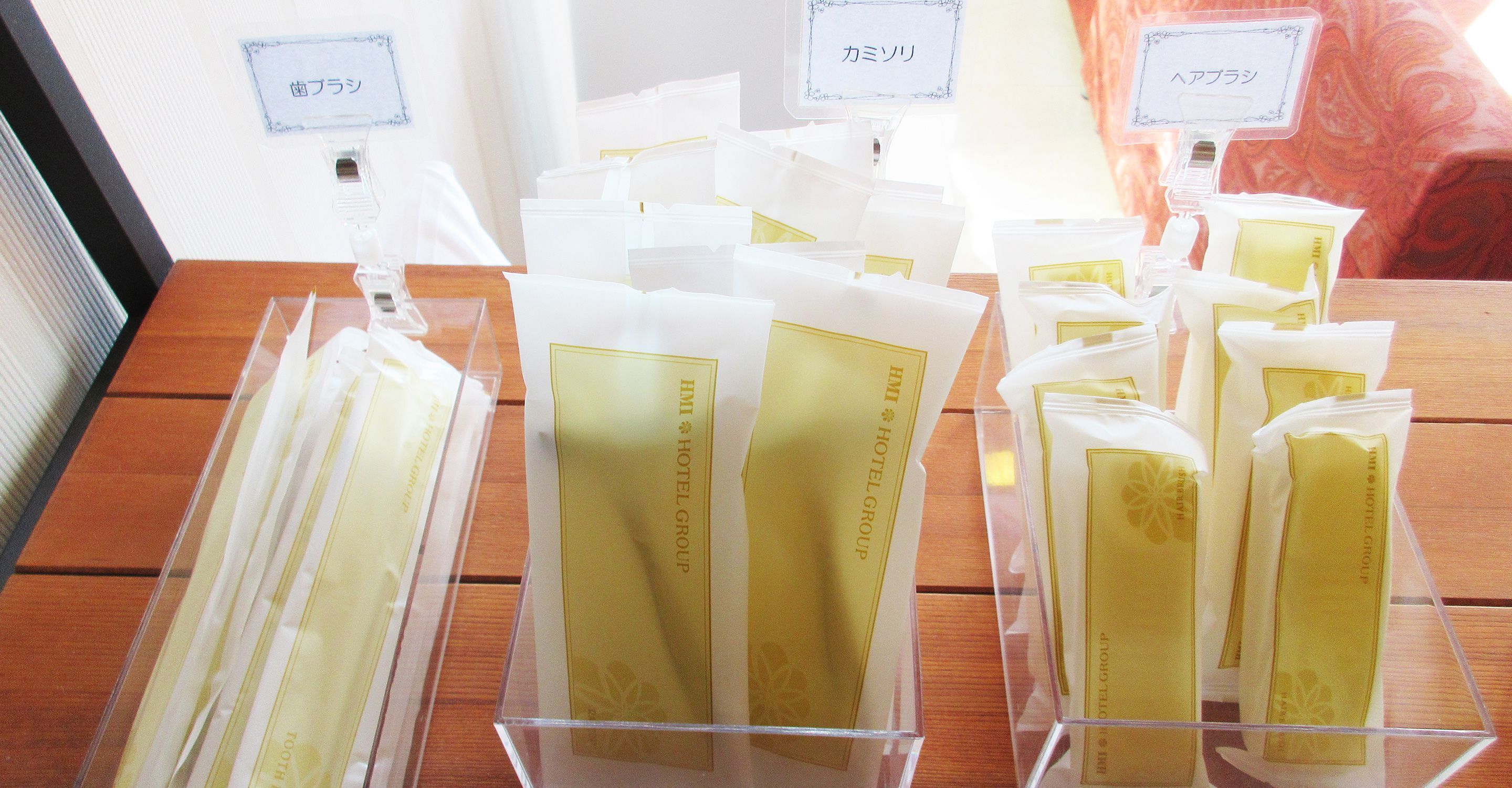 A display of hotel group branded toiletries in clear plastic containers.