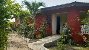 Un bâtiment rouge avec un chemin en béton menant à l’entrée.