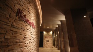 Un couloir avec un mur en briques et une enseigne indiquant « Richmond Hotel ».