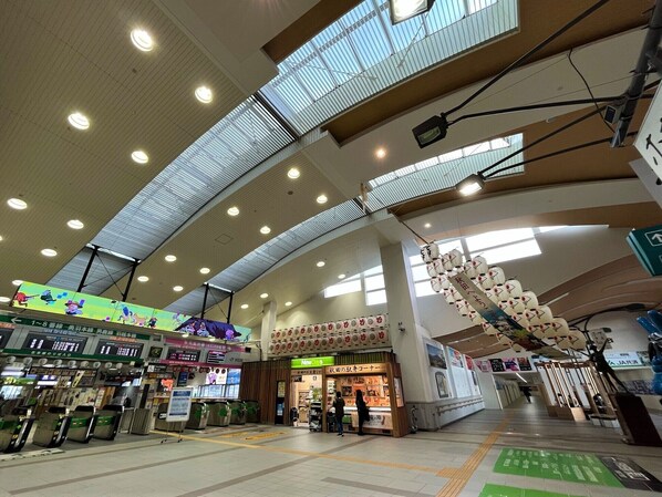 A spacious indoor area with a high ceiling, multiple light fixtures, and a large display screen.